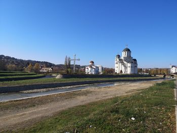 Church by building against clear blue sky