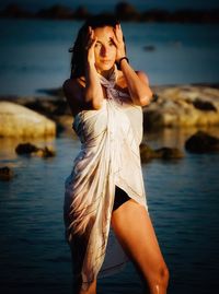 Portrait of sensuous woman standing at beach