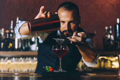 Midsection of man preparing food in bar