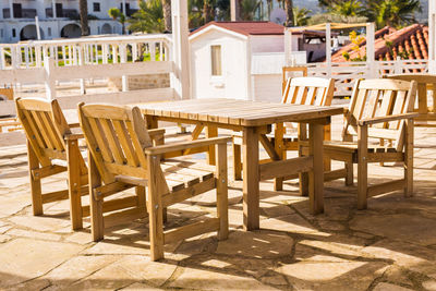 Empty chairs and tables in cafe against bright sun