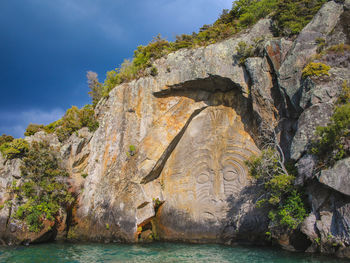 Rock formations by sea against sky