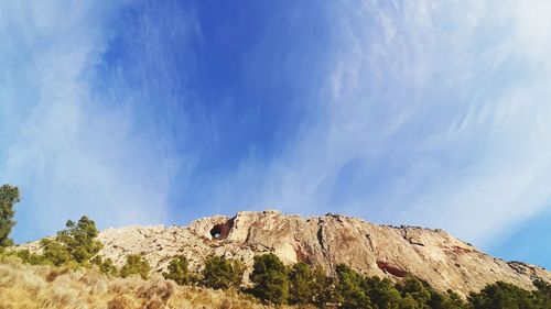 Low angle view of mountain against blue sky