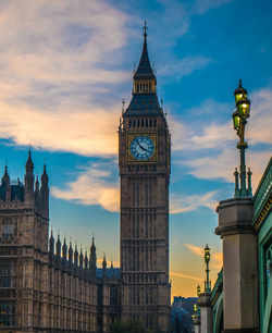 Clock tower in city against sky during sunset