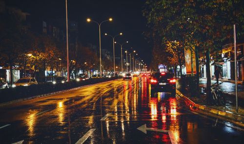 Illuminated city street during rainy season at night