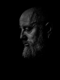 Close-up portrait of man against black background