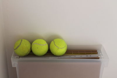 Close-up of balls on table against wall