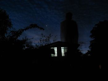 Silhouette trees against sky at night