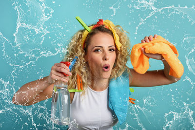 Portrait of woman holding spray bottle and napkin