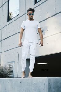 Portrait of handsome young man standing against building 