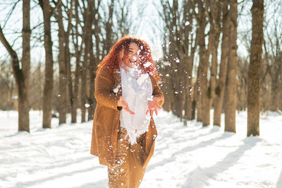 Fat caucasian woman playing snowballs in the park