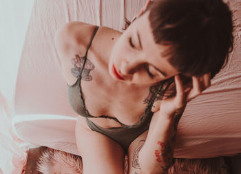 Close-up portrait of young woman lying on bed