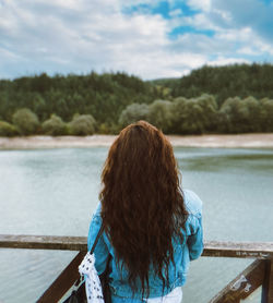 Rear view of woman looking at sea against sky