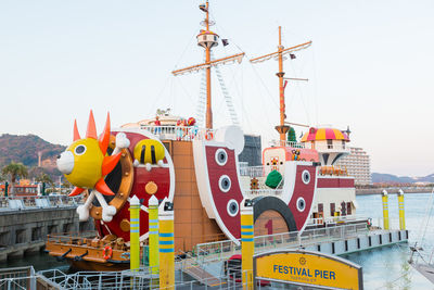 View of amusement park by sea against clear sky