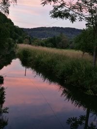 Scenic view of river against sky at sunset