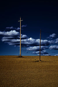 Electricity pylon on field against sky