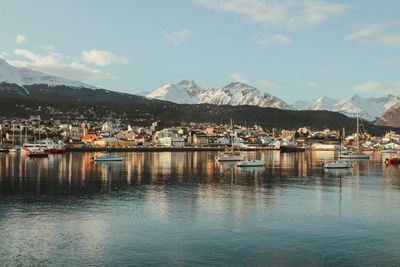 Buildings by lake against sky