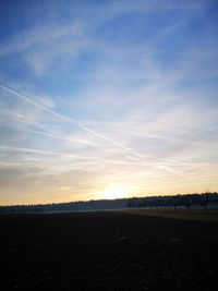 Scenic view of silhouette field against sky during sunset