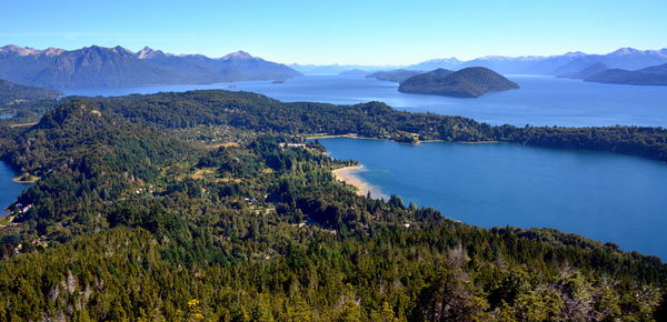 Scenic view of trees and mountains against blue sky