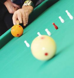 Close-up of person playing with ball on table
