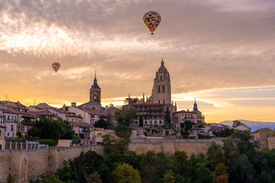 Hot air balloons flying against sky during sunset