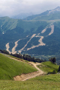 Green slope of a high mountain during a thunderstorm with clouds in the sky