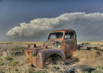 Abandoned truck on landscape against sky