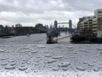 Close-up of wet road against buildings in city during rainy season