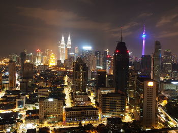 Illuminated cityscape against sky at night