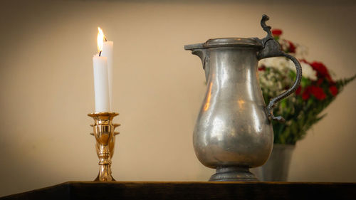 Close-up of electric lamp on table against wall