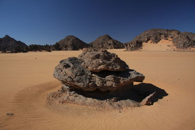 Rock formations on desert against clear sky acacus mountains, libya