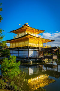 Exterior of building by lake against blue sky