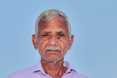 Portrait of man against blue sky