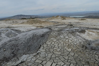 Surface level of barren land against sky