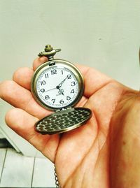 Close-up of hand holding pocket watch