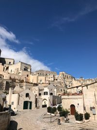 Buildings in city against blue sky