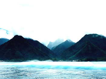 Scenic view of sea and mountains against sky