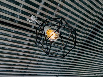 Low angle view of illuminated light bulbs hanging from ceiling