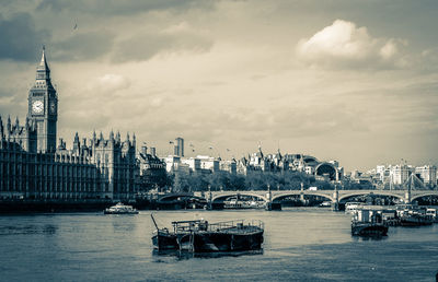 Boats in river with city in background