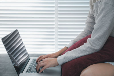 Midsection of woman using mobile phone