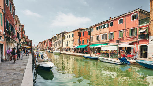 Boats in canal amidst buildings in city