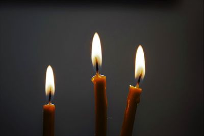 Close-up of lit candle against black background