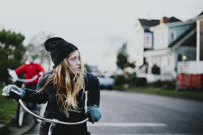 Girl looking away while cycling on street