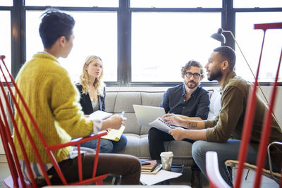 Entrepreneurs planning while sitting by window in office