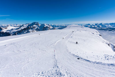 Scenic view of snowcapped mountains against blue sky