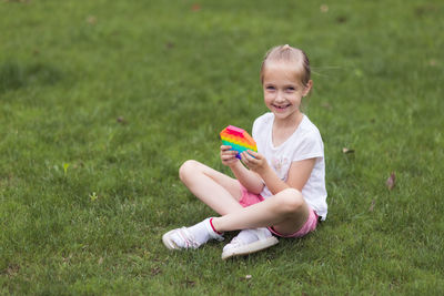 Portrait of cute girl sitting on field