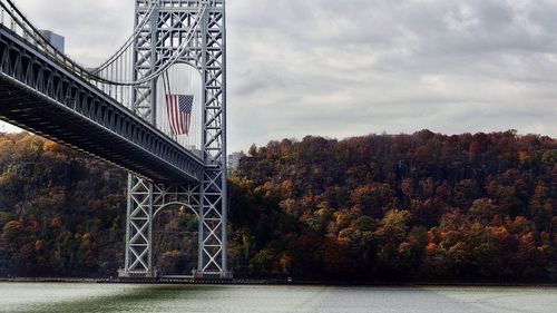 Bridge over river against sky during autumn