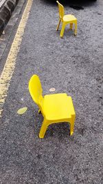 High angle view of yellow chair on road