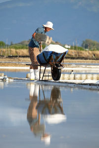 Reflection of young man working against sky