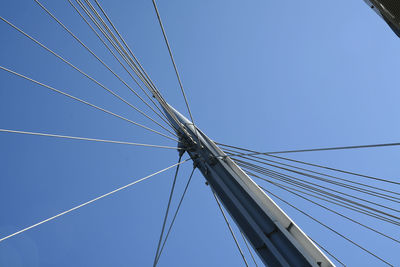 Low angle view of suspension bridge against clear blue sky