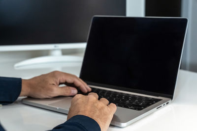 Cropped hands using laptop